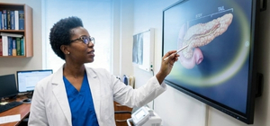Doutora mostrando um p&acirc;ncreas humano em um monitor digital. 